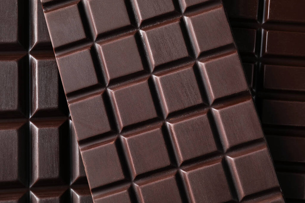 Many delicious dark chocolate bars as background, top view - Foto, imagen