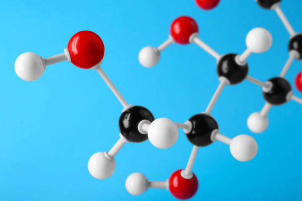 Molecule of glucose on light blue background, closeup. Chemical model - Zdjęcie, obraz