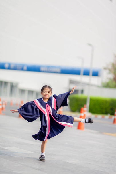 Happy Asian girls in graduation gowns on their graduation day at school.Graduation concept with copy space.	 - Fotoğraf, Görsel
