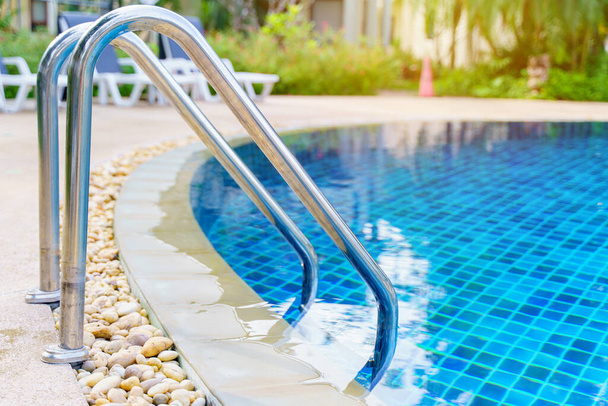 blauw zwembad bij hotel met trap - Foto, afbeelding