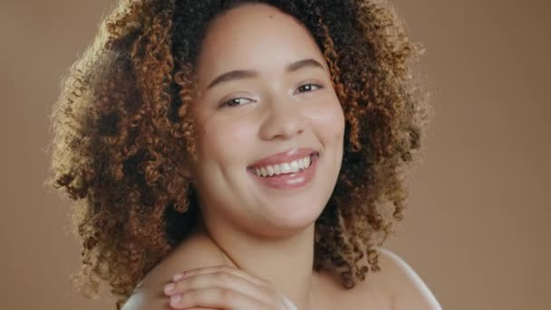Zwarte vrouw, lach en gezicht van een cosmetisch en wellness model in een studio met geluk. Huidgloed, cosmetica portret en Afrikaanse persoon met een glimlach van schone huid met bruine achtergrond. - Video