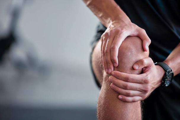 Χέρια, γόνατο και πόνος με έναν αθλητή που κρατάει κάκωση άρθρωσης ενώ προπονείται σε γυμναστήριο για την υγεία. Καταλληλότητα, ατύχημα και ανατομία με έναν άνδρα αθλητή που πάσχει από τραυματισμένο σώμα κατά τη διάρκεια της άσκησης. - Φωτογραφία, εικόνα
