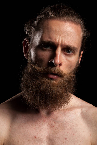 Tattooed bearded hipster on black background in studio photo. Expression and fashion - Fotoğraf, Görsel