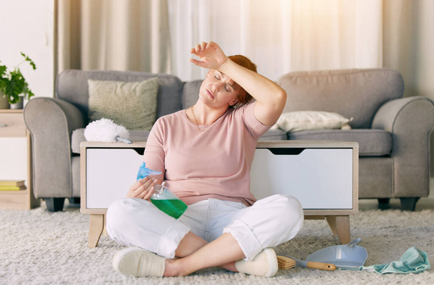 Tired woman, housekeeping and detergent from spring cleaning services in living room on floor at home. Exhausted female maid or cleaner in burnout, stress or fatigue for routine maintenance in lounge. - Valokuva, kuva