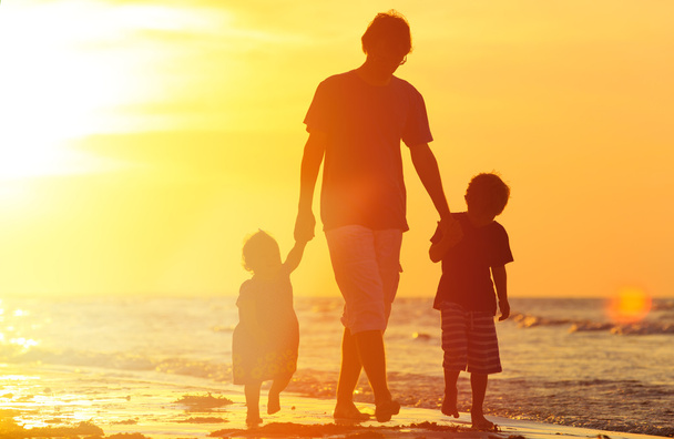 πατέρα και δύο παιδιά περπάτημα στο ηλιοβασίλεμα - Φωτογραφία, εικόνα