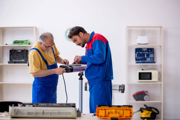 Deux réparateurs travaillant à l'atelier - Photo, image