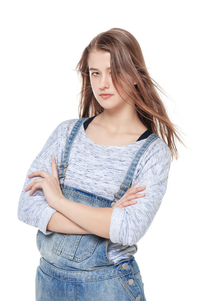 Молода дівчина моди в джинсовому комбінезоні позує ізольовано
  - Фото, зображення