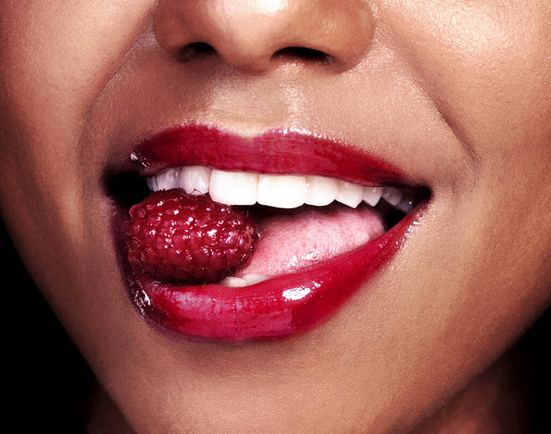 Very berry. an unrecognizable woman posing with a cherry in her mouth - Foto, afbeelding