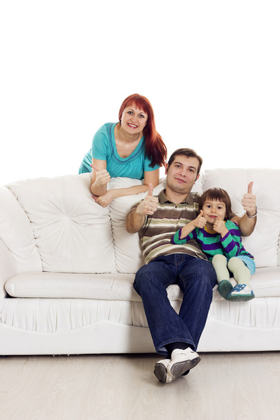 Vater, Mutter und Sohn sitzen auf dem Sofa und zeigen Handzeichen - Foto, Bild