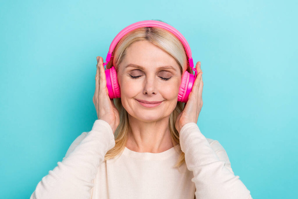 Photo of sweet dreamy lady dressed white shirt closed eyes listening songs headphones isolated teal color background. - 写真・画像