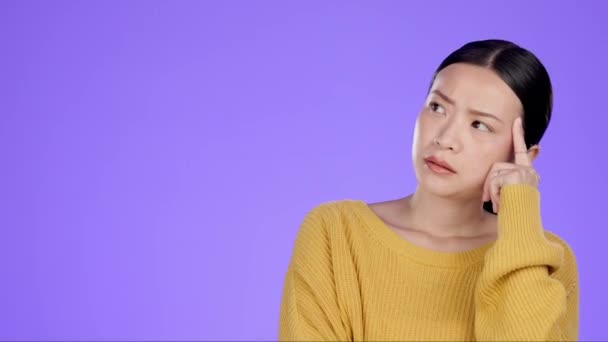 Aasialainen nainen, miettien ja miettien mockup harkitsee vastaan violetti studio tausta. Eristetty huomaavainen nainen ihme, ajatellut tai ajatella ratkaisu tai ongelmanratkaisu kopioi tilaa. - Materiaali, video