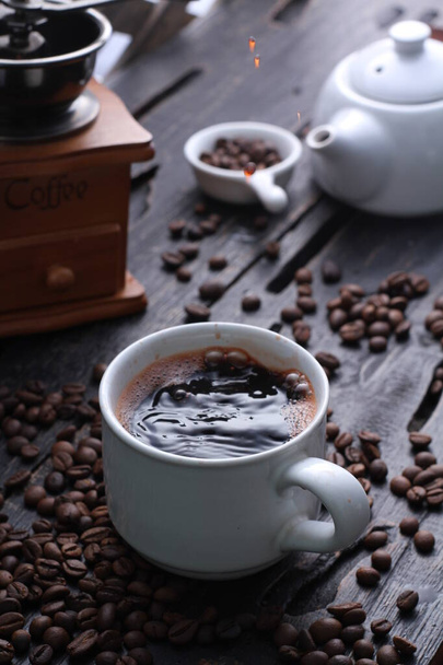 Coffee is a drink prepared from roasted coffee beans. Darkly colored, bitter, and slightly acidic, coffee has a stimulating effect on humans, primarily due to its caffeine content. It has the highest sales in the world market for hot drinks. - Photo, Image