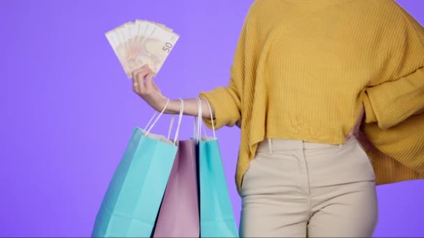 Shopping bag, cash and retail with hands of woman for spree, payment and luxury. Wealth, promotion and boutique with customer and money isolated on studio background for offer, bonus and discount. - Footage, Video