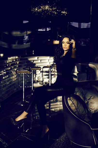 woman with dark hair in elegant clothes posing in luxury interior    - Foto, imagen
