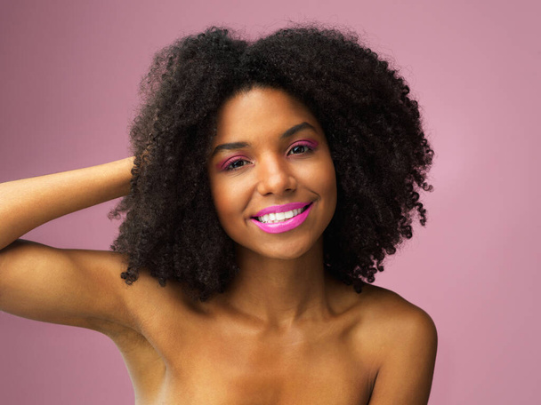 Happy with the health of my hair. Studio shot of an attractive young woman posing against a pink background - Foto, Imagen