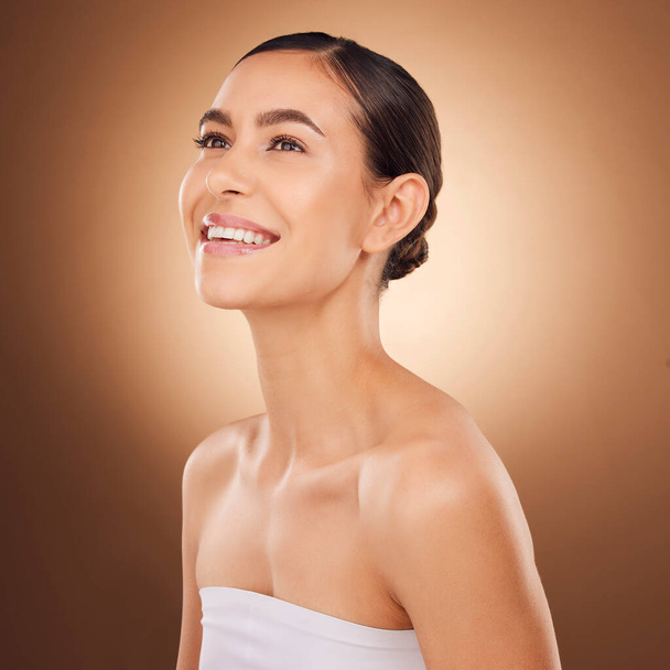 Studio face, happy and beauty woman with luxury facial cosmetics, natural makeup and skincare glow. Dermatology healthcare satisfaction, spa salon person or aesthetic female model on brown background. - Foto, Imagem