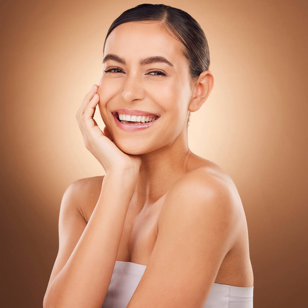 Skincare satisfaction, face portrait and happy woman with luxury facial cosmetics, natural makeup glow and studio beauty. Dermatology, spa salon person and aesthetic female model on brown background. - Foto, Imagen