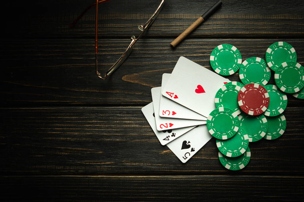 Jouer au poker avec une combinaison de cartes haute gagnante. Cartes avec jetons sur une table vintage noire dans un club de poker. - Photo, image
