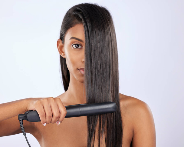 Portrait, woman or hair straightener in studio for beauty self care or treatment isolated on white background. Face, Indian girl model or salon equipment for ironing in grooming routine for styling. - Valokuva, kuva