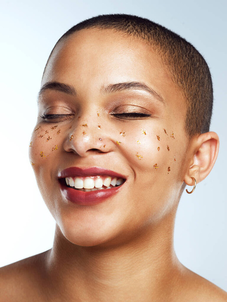 I wouldnt change a thing about myself. Studio shot of a beautiful young woman posing with glitter freckles on her face - Photo, image