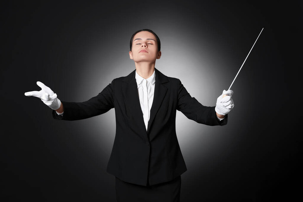 Professional conductor with baton on black background - Zdjęcie, obraz