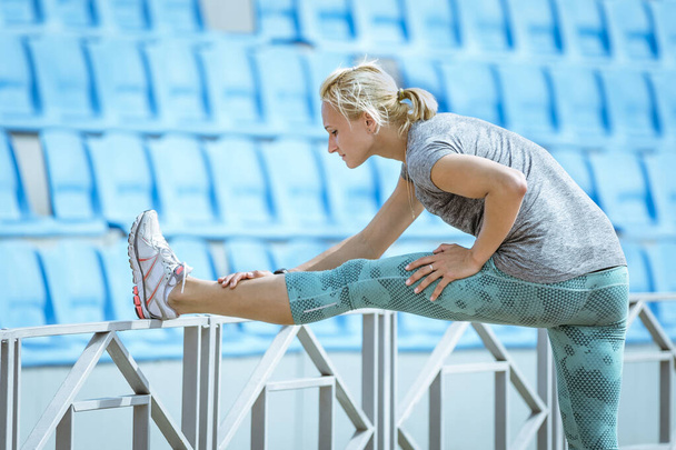 corredor feminino fazendo exercício de alongamento, inclinar para a frente para a perna, aquecimento antes do treinamento de atletismo - Foto, Imagem