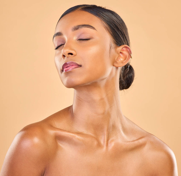 Beauty, face and skin of woman in studio for skincare, cosmetics, dermatology or makeup. Aesthetic female .eyes closed for self care, natural shine and spa facial results on a brown background. - Фото, изображение