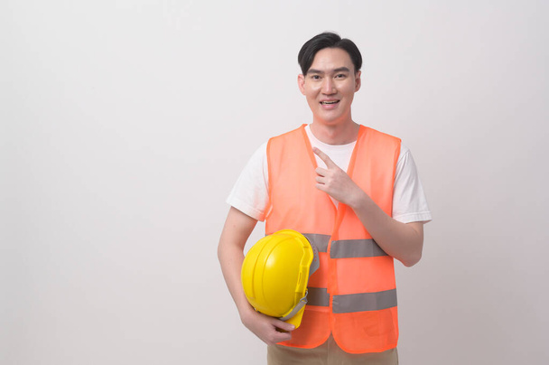 Portrait of male engineer wearing a protective helmet over white background studio. - 写真・画像