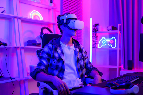 Young Caucasian man Pro Gamer have live streaming  playing video game,  using virtual reality glasses at home - Fotografie, Obrázek