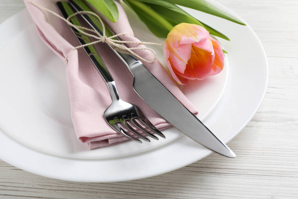 Stylish table setting with cutlery and tulip on white wooden background, closeup - Foto, Imagem