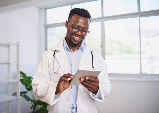 Porträt eines jungen schwarzen Arztes mit digitalem Tablet im hellen Büro. Hochwertiges Foto - Foto, Bild