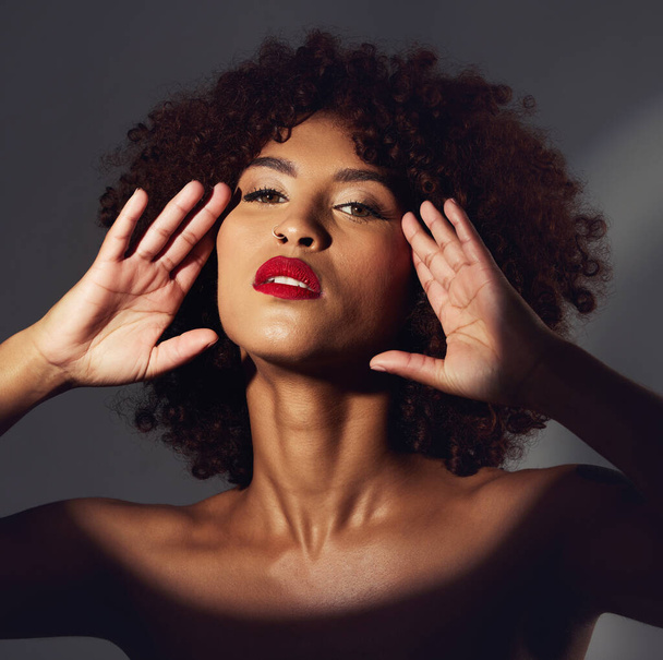 Black woman, red lipstick and spotlight with beauty and makeup in portrait, hands frame face on studio background. Cosmetics, creative and aesthetic with beautiful female, cosmetology and art deco. - Φωτογραφία, εικόνα