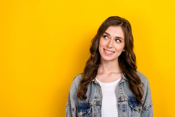 Portrait of cheerful adorable minded girl beaming smile look empty space isolated on yellow color background. - Φωτογραφία, εικόνα