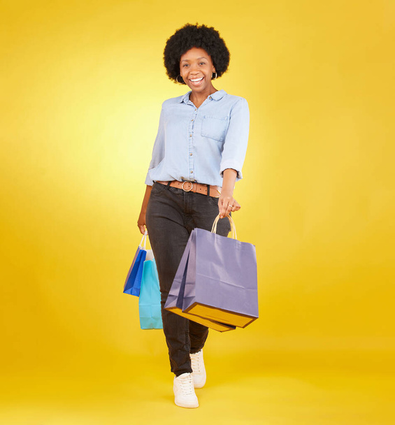 Black woman with shopping bag, portrait with fashion and retail, smile on yellow studio background. Happiness, female with discount and sale at boutique with designer brand, happy and mockup space. - Fotografie, Obrázek