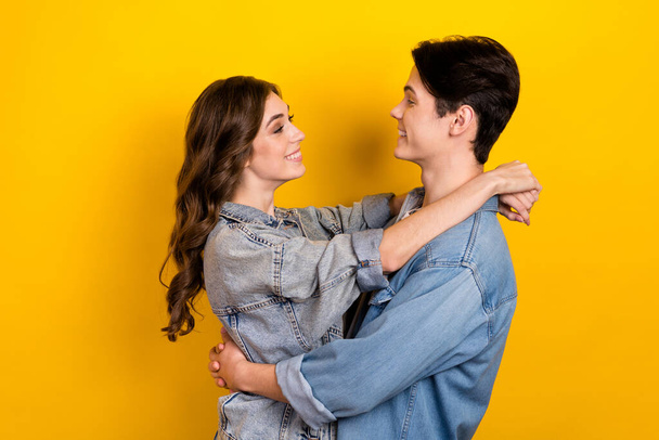 Profile portrait of two lovely cute partners cuddle look each other isolated on yellow color background. - Valokuva, kuva