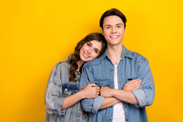 Portrait of two positive friendly people toothy smile crossed arms hug isolated on yellow color background. - Foto, immagini