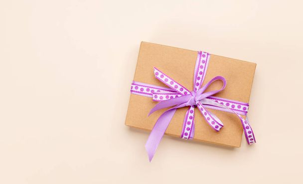 Handmade gift box with purple ribbon. Flat lay with copy space - Φωτογραφία, εικόνα