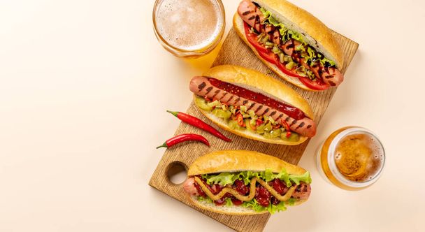 Various hot dog and beer. Homemade hotdogs on cutting board. Flat lay with copy space - Zdjęcie, obraz