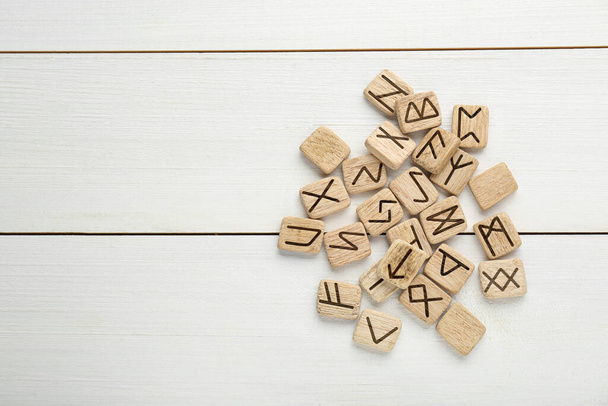 Pile of runes on white wooden table, flat lay. Space for text - Foto, Imagem
