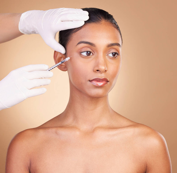 美容と皮膚科の女性、顔と針、スタジオの背景にプラスチック手術でスキンケア。女性,手と皮膚の注射,顔の治療と目を閉じて化粧品の手順. - 写真・画像