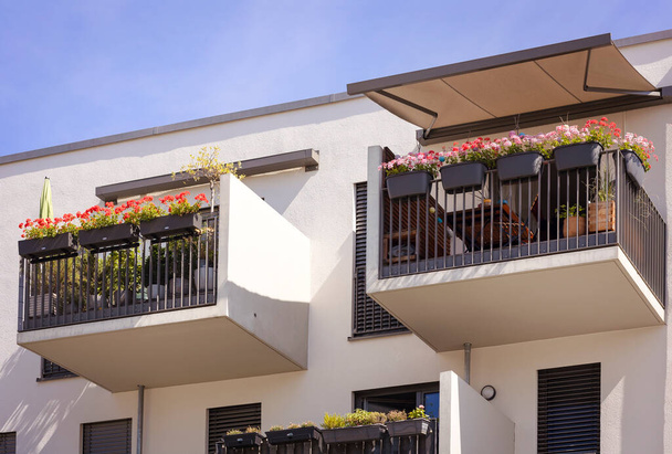 Balcony of Modern Apartment Building with Sunshade Protection Awning Marquise, Flowers in jardinieres at Terrase of Residential Building - Photo, Image