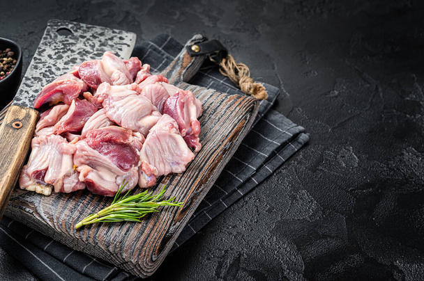 Raw chicken stomachs, giblets gizzards on a butcher board with meat cleaver. Black background. Top view. Copy space. - Φωτογραφία, εικόνα