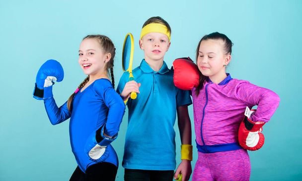 Energy inside. Fitness energy health. punching knockout. Team sport success. workout of small girls boxer and boy in sportswear. Happy children in boxing gloves with tennis racket and ball. - Photo, Image