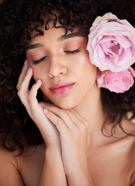 Flowers, rest and face of woman with makeup, cosmetics and beauty for wellness, glamour and glow in studio. Salon aesthetic, spa and girl with closed eyes for natural, skincare and facial treatment. - Valokuva, kuva