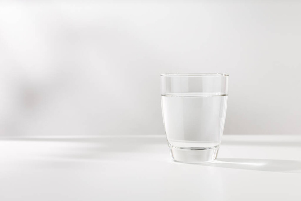 Pure water in the glass is on the white wooden table. - Fotoğraf, Görsel