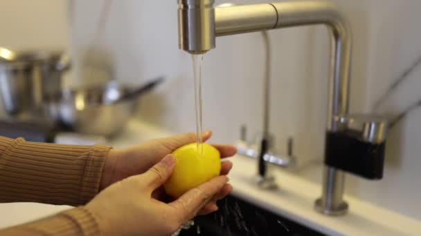 Nainen pesee sitruunaa pesualtaassa. - Materiaali, video