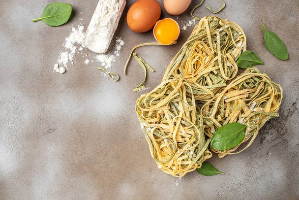Fresh pasta and ingredients. green and yellow pasta tagliatelle. banner, menu, recipe place for text, top view. - Photo, image
