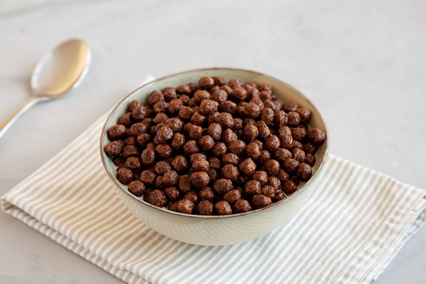 Chocolate Puff Cereal mit Milch in einer Schüssel, Seitenansicht. - Foto, Bild