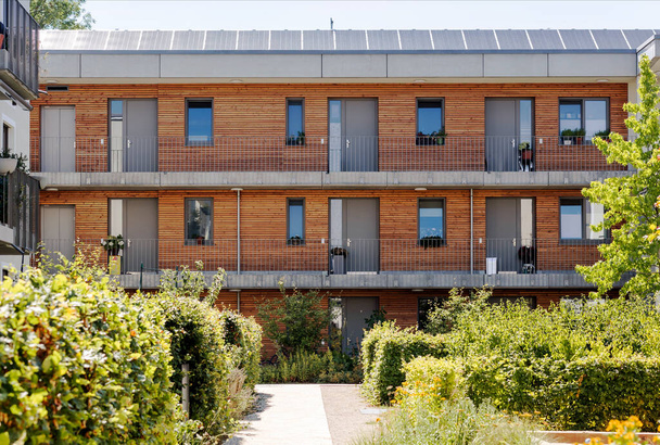 Multi-family House or Modern Apartment Building with Solar Panel, Wooden Facade and Community Garden Landscape is Trendy of Urban Construction in Europe, Germany. Eco Housing concept. - Photo, Image
