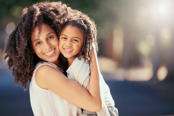 Black mother with girl child hug in a park with summer lens flare for love, care or growth development outdoor wellness. Happy natural mom bonding with kid in nature portrait together for mothers day. - Photo, Image